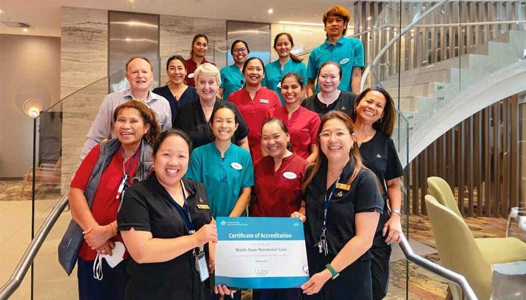 A group of staff from Middle Swan Residential Care holding the facility's Certificate of Accreditation